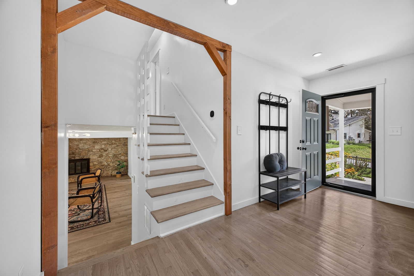 Entry foyer with exposed timber-frame archway and staircase