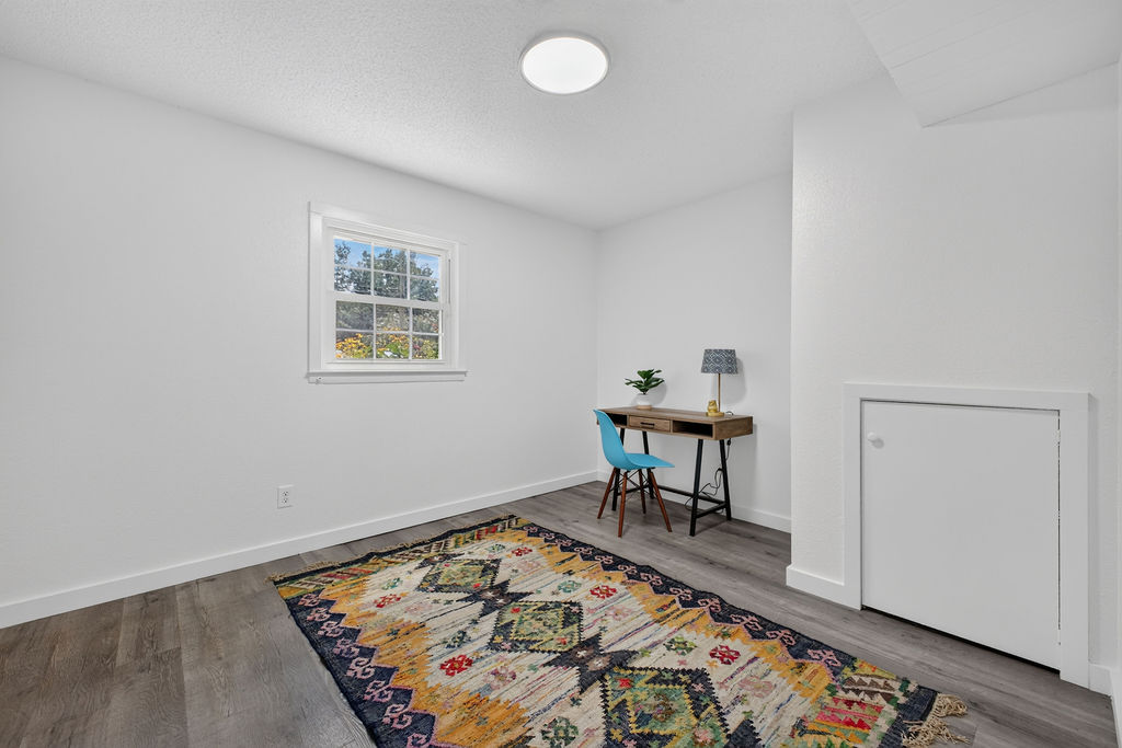 Lower-level bedroom currently arranged as a home office with desk and chair