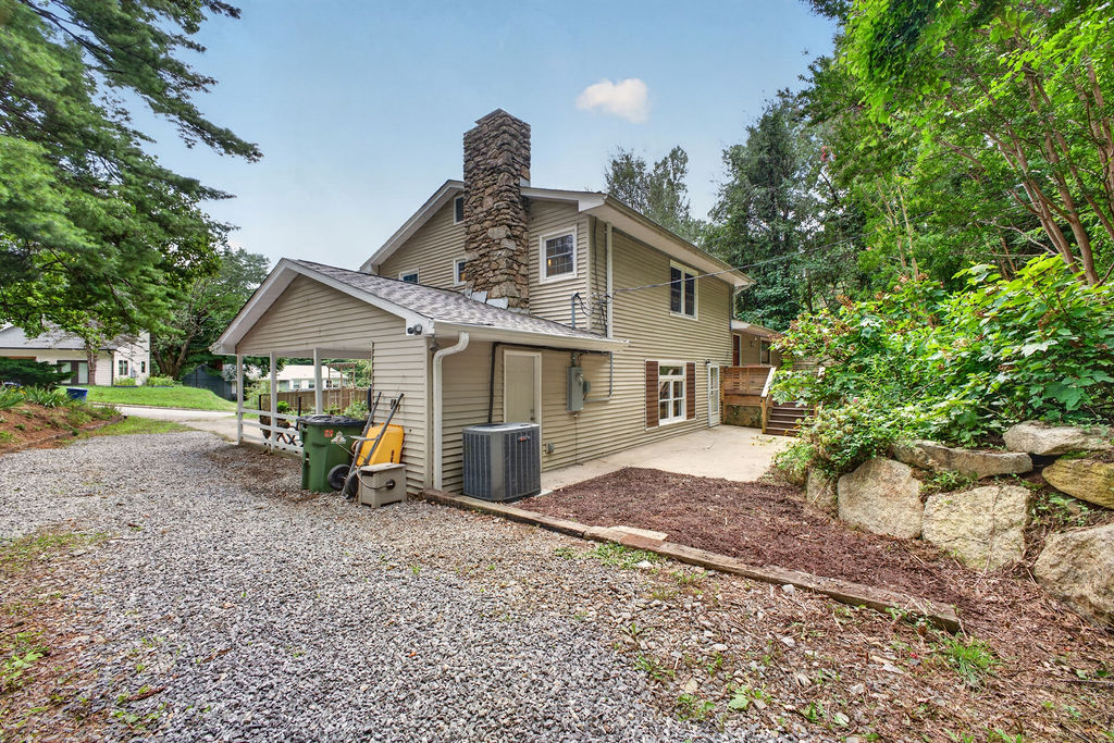 Carport and side of the home showing the separate lower-level entrance