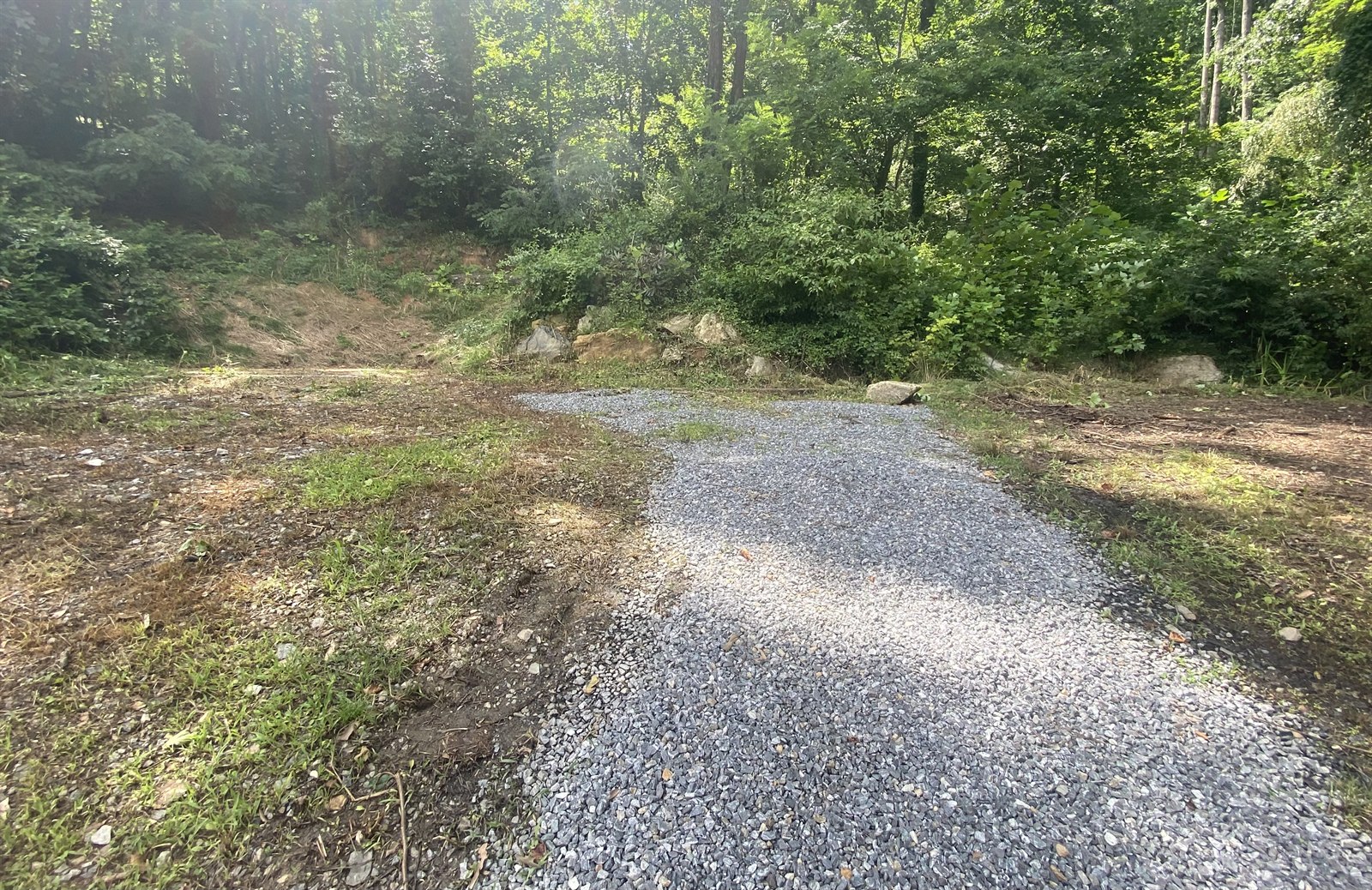 Cleared, leveled and graded gravel building pad at the rear of the property, ready for construction